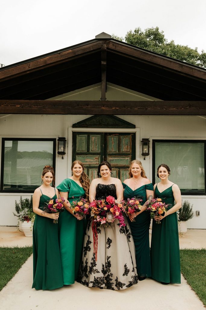 Emerald green bridesmaids dresses, colorful bouquets and a unique wedding gown.