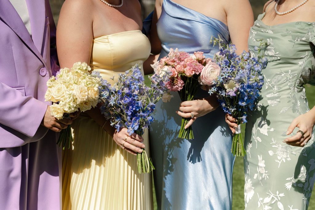 Bridesmaids bouquets featuring roses, delphinium, ranunculus, stalk, and sweet pea. Created by Austin wedding florist, Flora Fetish.
