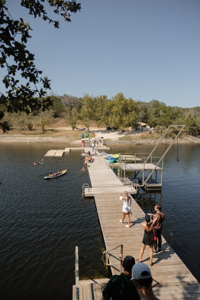An Austin Texas Hill Country wedding weekend at the Retreat at Balcones springs resort. This weekend long wedding extravaganza featured lots of thoughtful details, personal touches, colorful florals, and intentional experiences for the guests. In the afternoon guests walked down to the lake to float in the water, play on the blob, watch the football game and go zip lining!